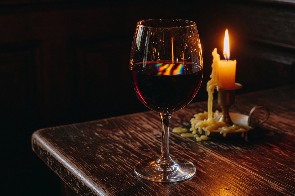 Ein Glas Blaufränkisch neben einer brennenden Kerze